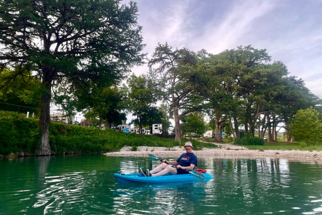 Man kayaking on the Frio River in front of Camp Riverview