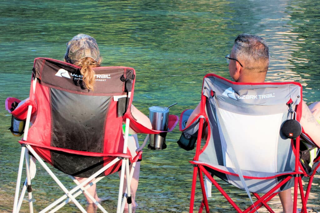 Couple relaxing at the bank of the Frio River at Camp Riverview
