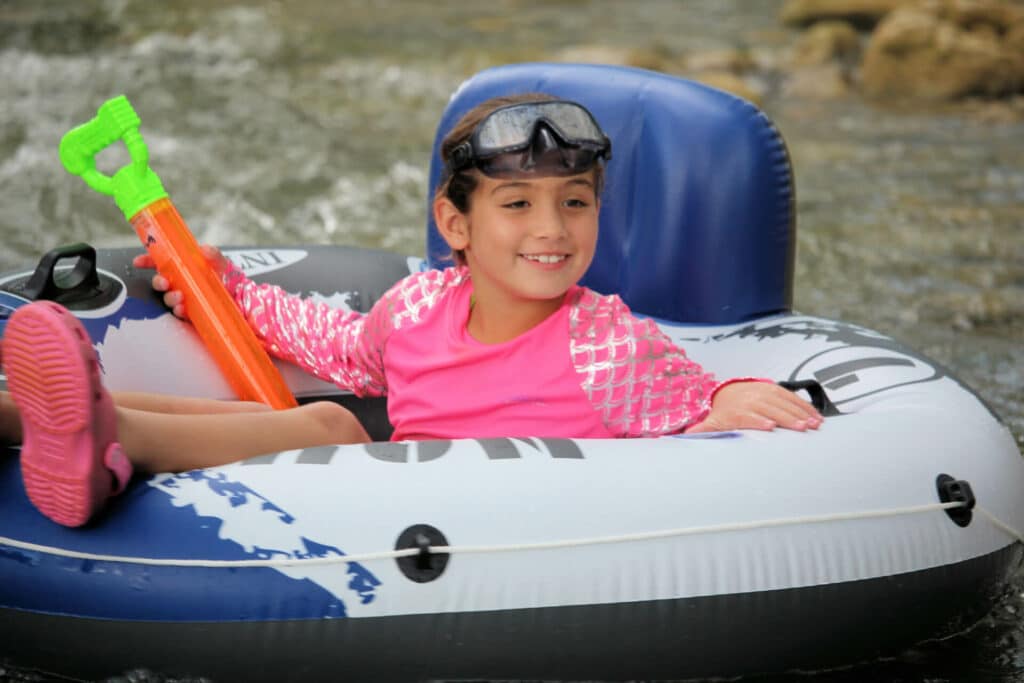 A young girl floating down the Frio River in a tube