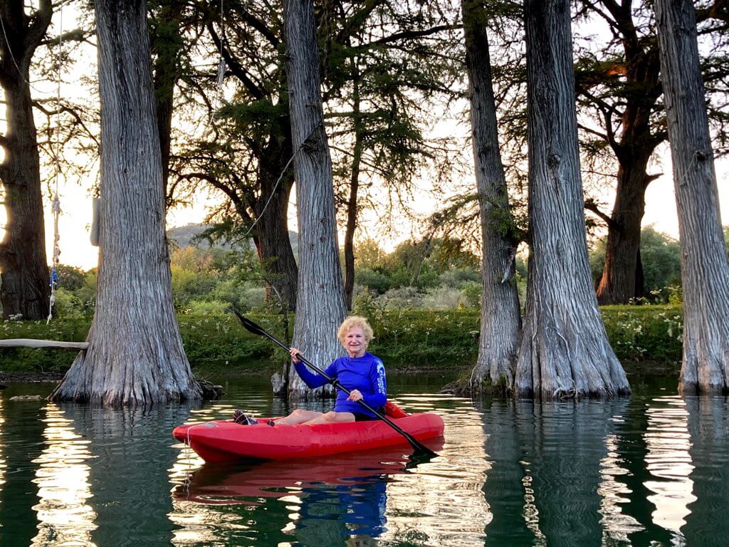 Woman kayaking in the Frio River at Camp Riverview